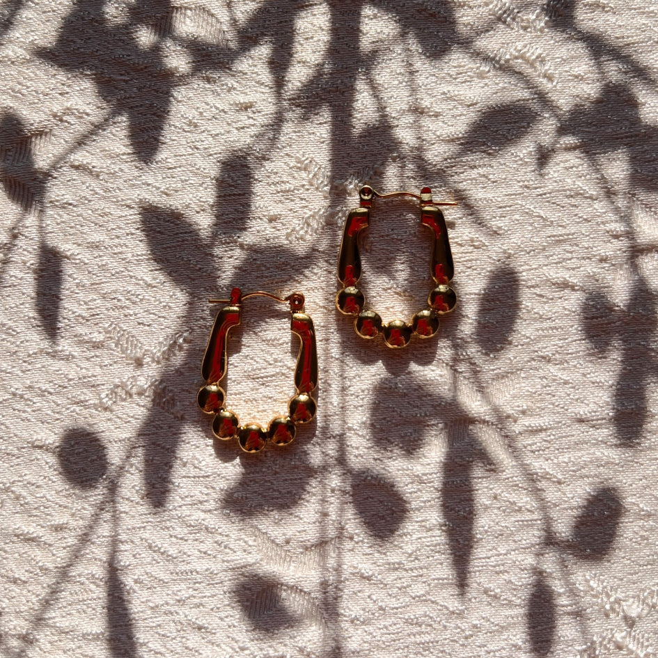 Boucles d'oreilles créoles dorées à billes – Élégance et modernité